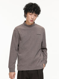 ダークブラウンの長袖ハイネックTシャツ、胸元に刺繍ロゴ