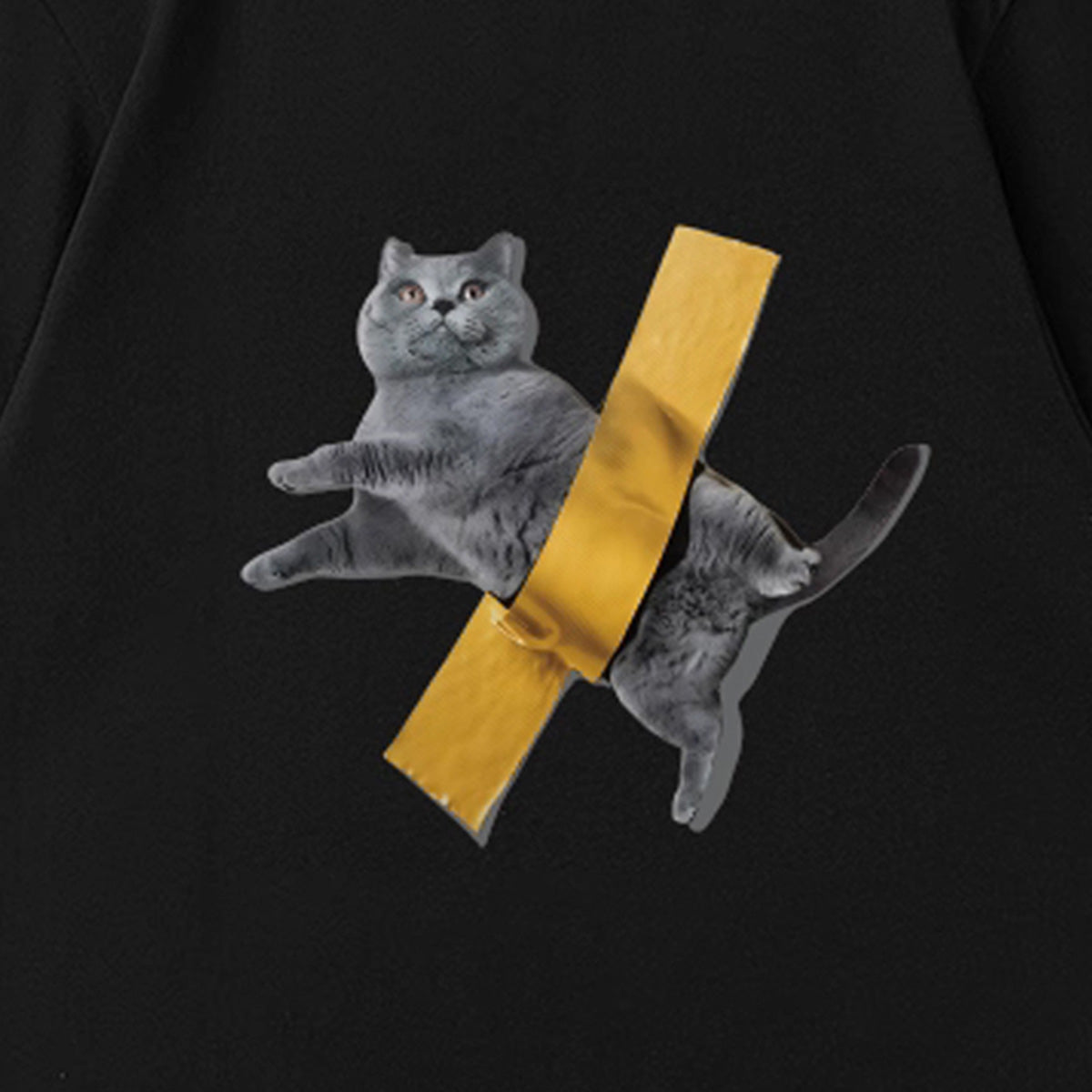 黒いTシャツ胸元アップ、灰色の猫と黄色テープ柄プリント