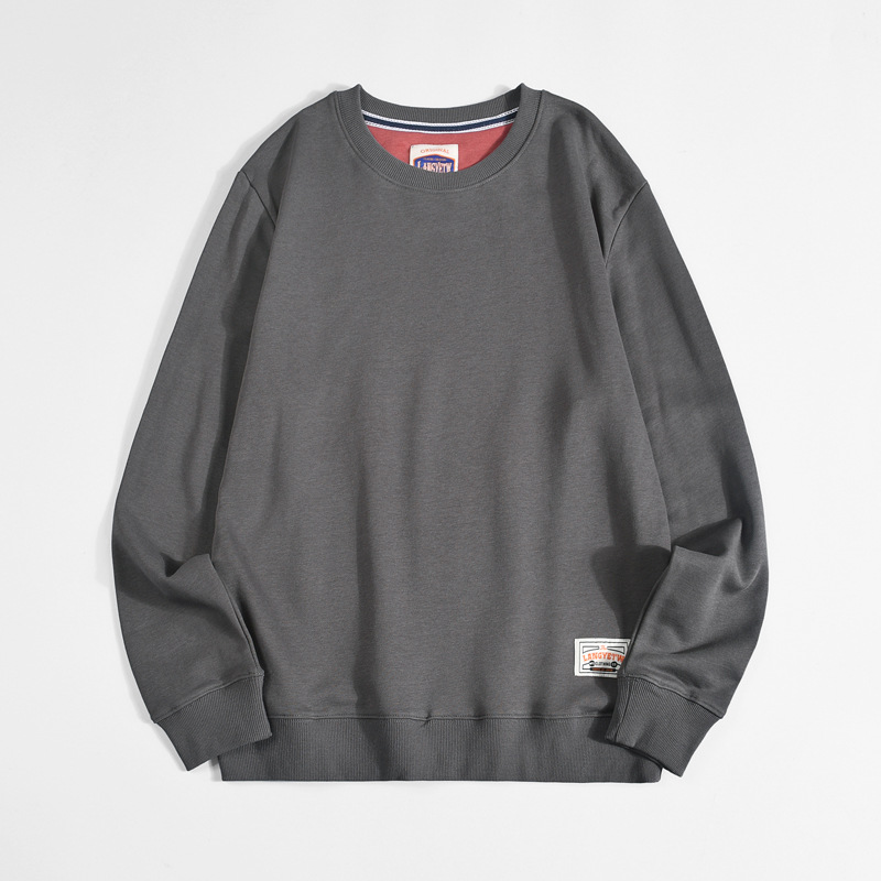 ダークグレーのクルーネック長袖Tシャツ、袖口ロゴパッチ付き