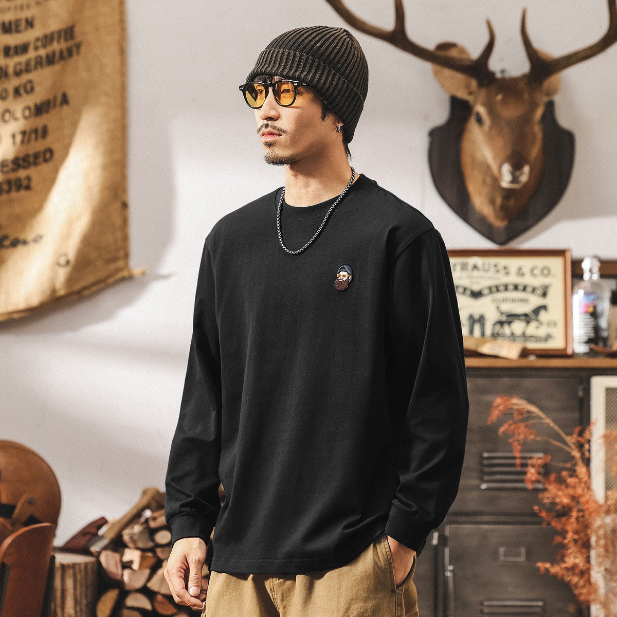 黒の長袖Tシャツ、胸の丸ロゴワッペン