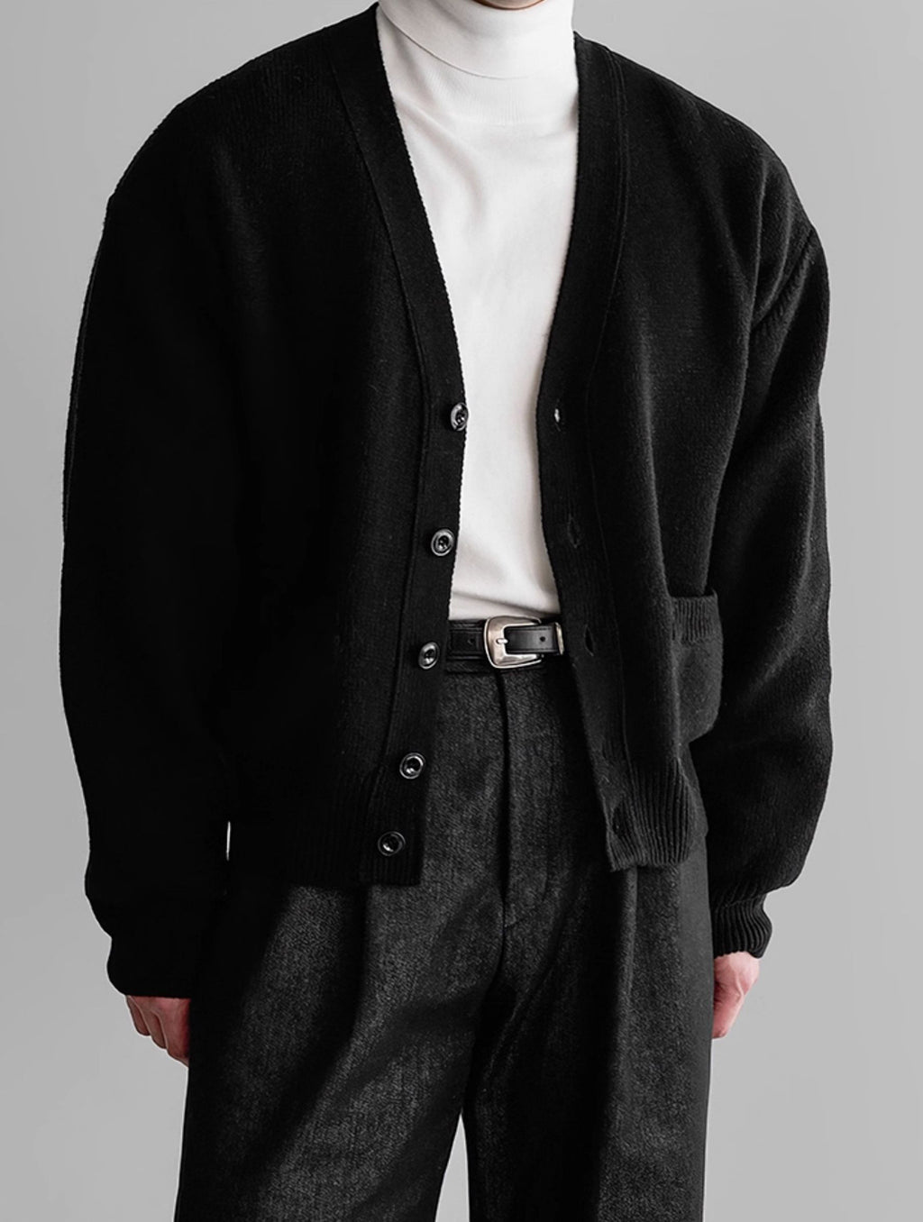 ブラックのニットセータージャケット、ボタン留めVネック、リブ袖口
