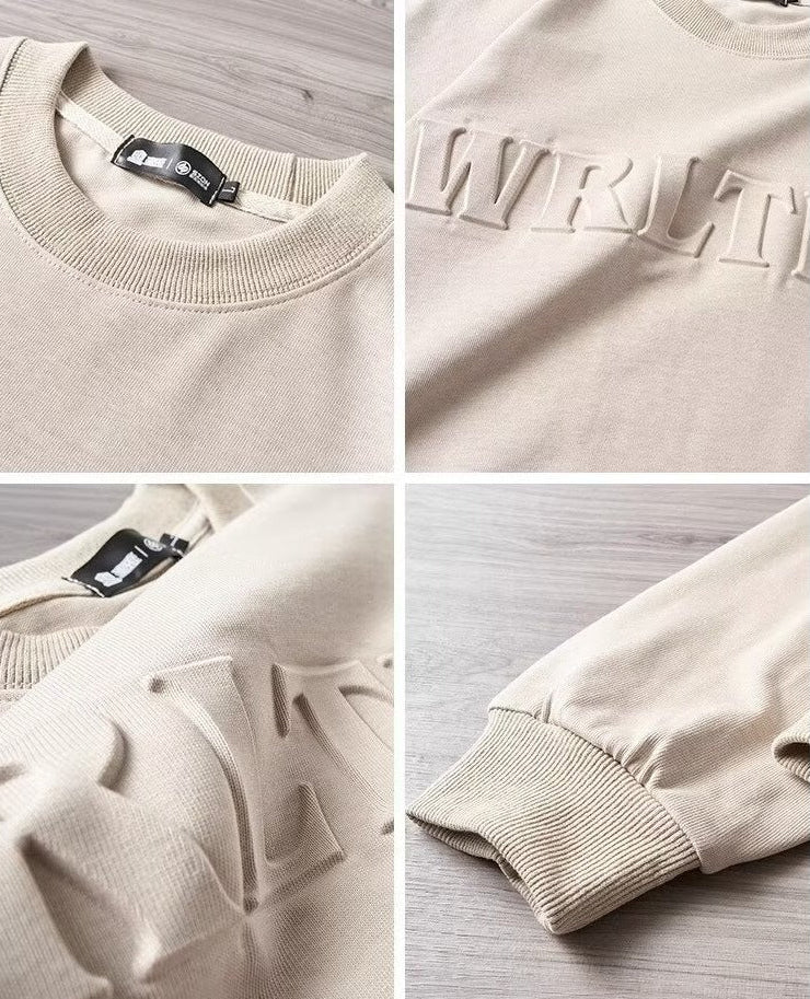 メンズ長袖Tシャツのディテール。ベージュ系のリブ襟と袖口、胸元の立体ロゴ