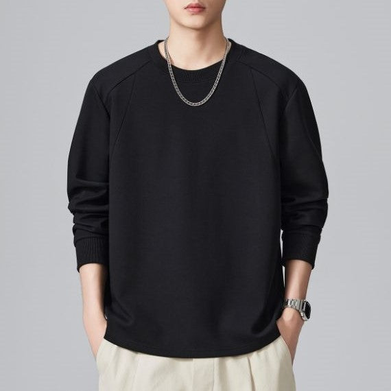 メンズ長袖Tシャツ、黒のラウンドネック無地。ゆったりした丸みのあるシルエット。