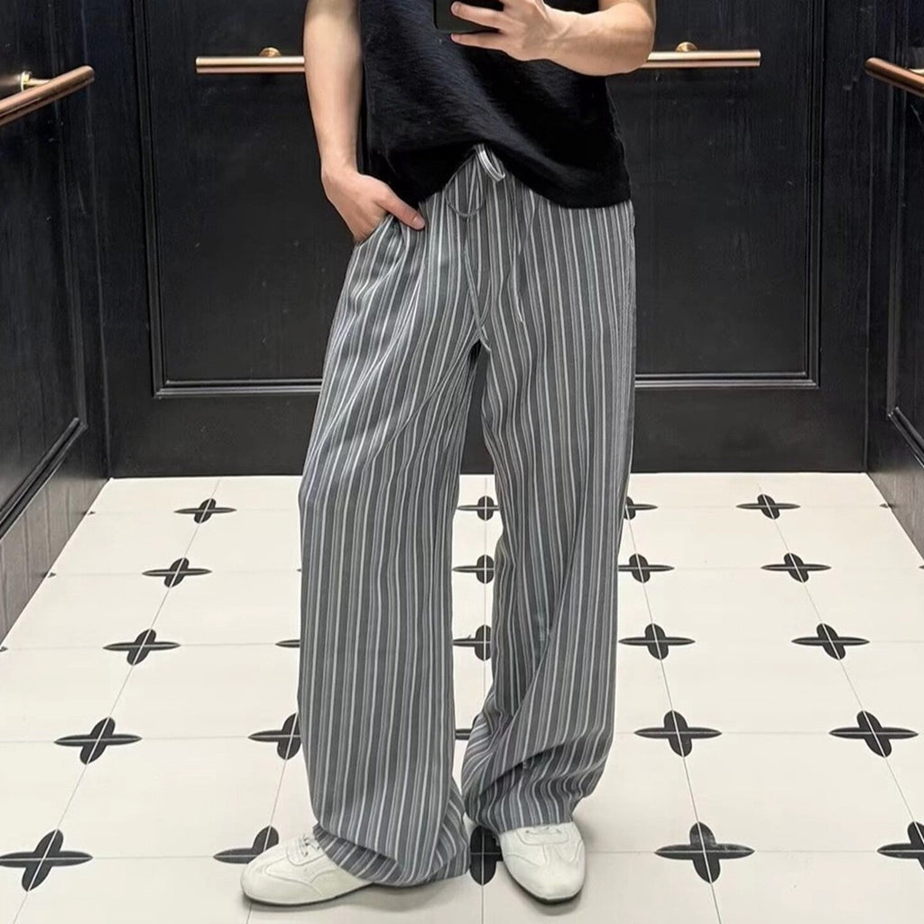 グレーのメンズ縦縞ワイドパンツ、ゆったりしたシルエットと長い裾