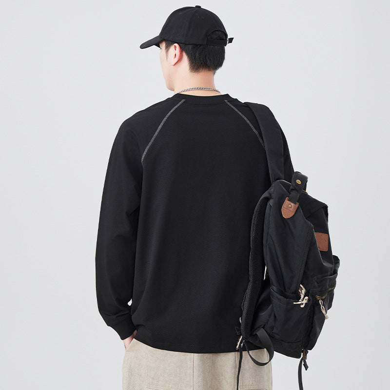 ブラックのゆったり長袖Tシャツ、ドロップショルダー、背面シルエットと後ろプリント