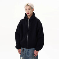 黒のジップアップパーカー。フロントファスナーを閉じたゆったりシルエット