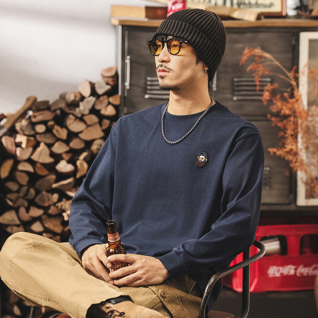 ネイビーの長袖Tシャツ、胸の丸ロゴワッペン