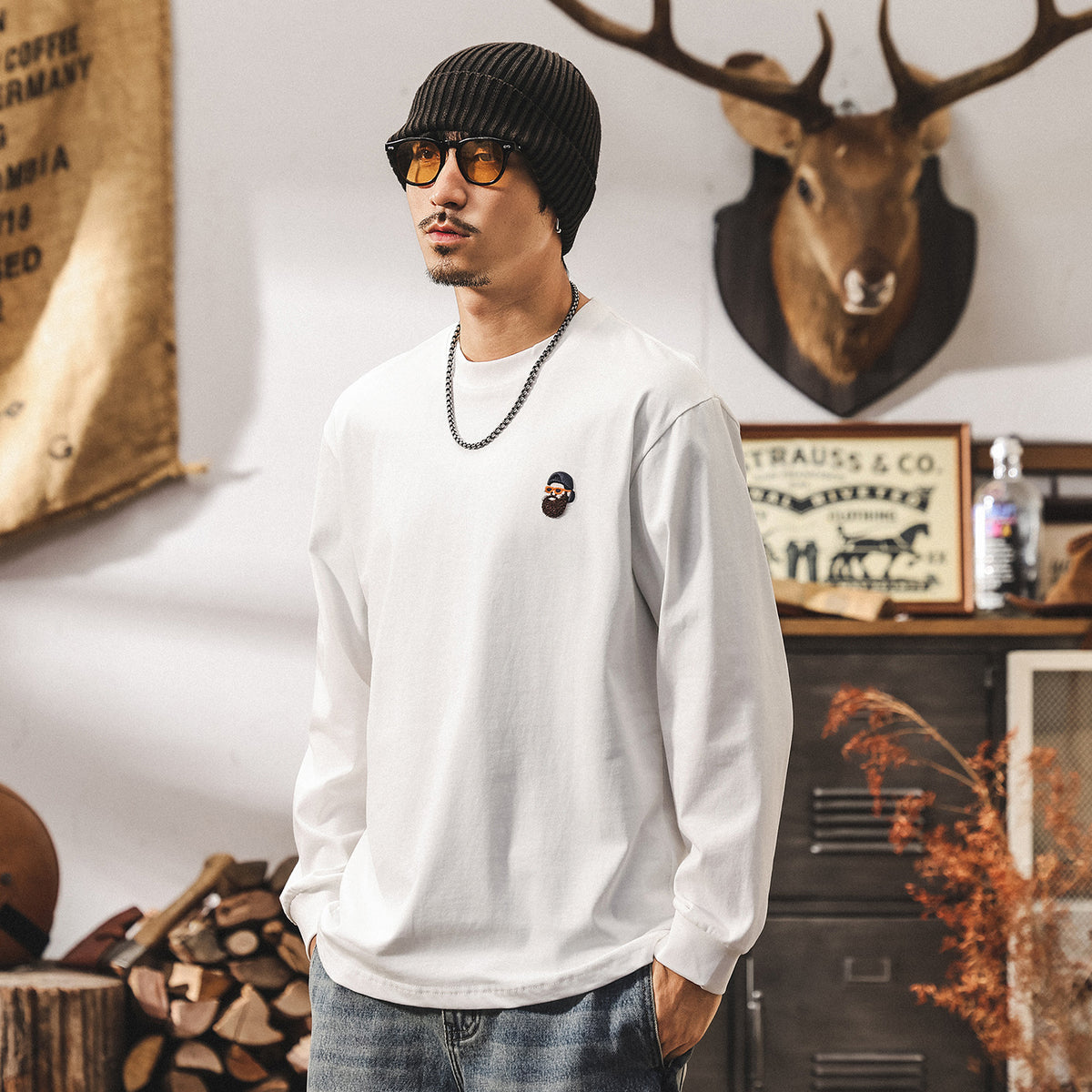 白の長袖Tシャツ、胸の丸ロゴワッペン付き