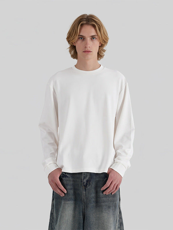 ホワイトの長袖Tシャツ、クルーネック、ボクシーなシルエット