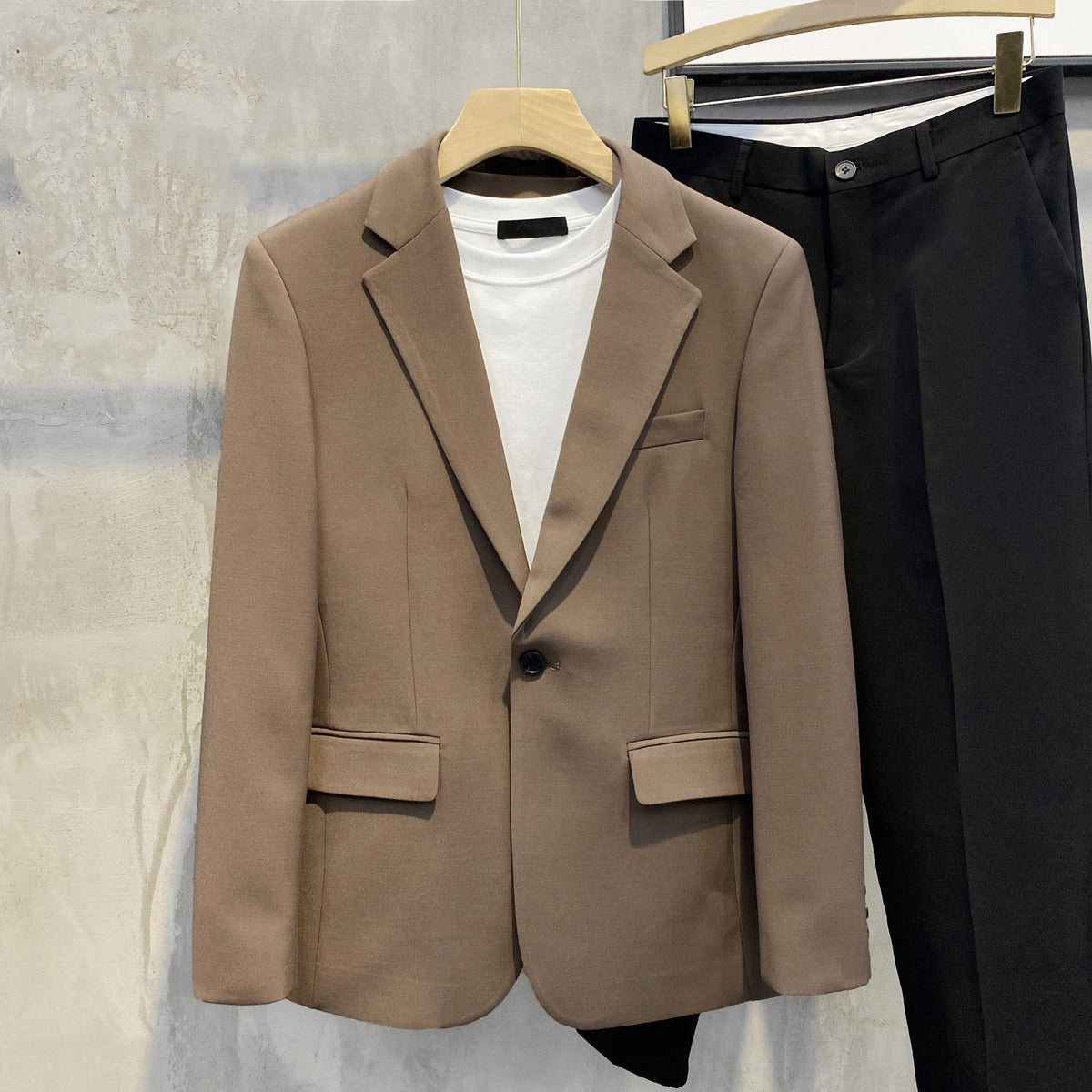 メンズシングルスーツジャケット。ブラウン系で、ノッチドラペルとフラップポケット付き